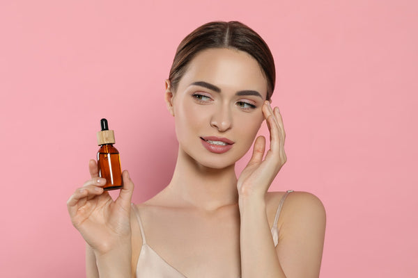 Young woman with bottle of skincare product