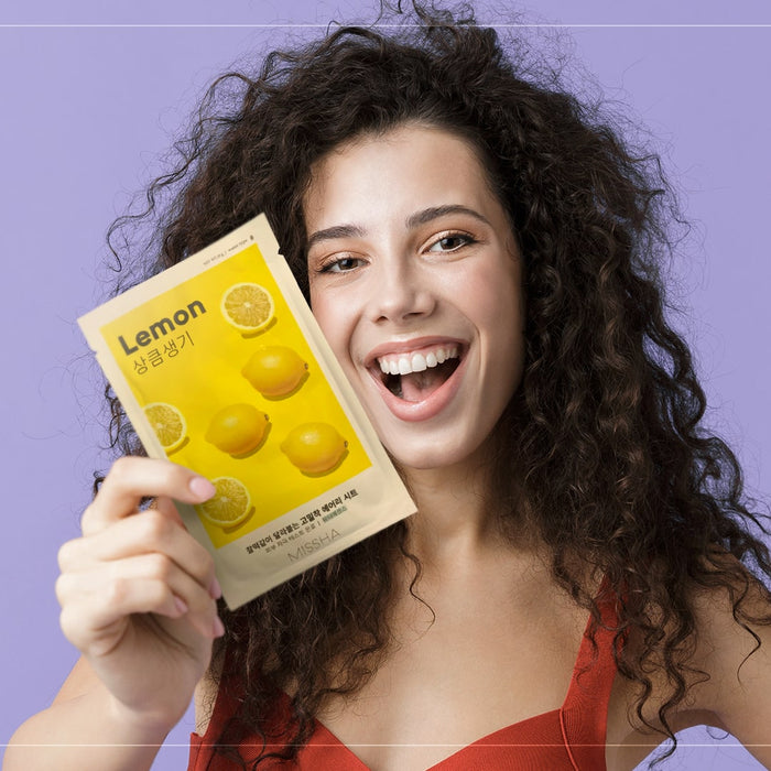 A Woman Holding A Sheet Mask Lemon