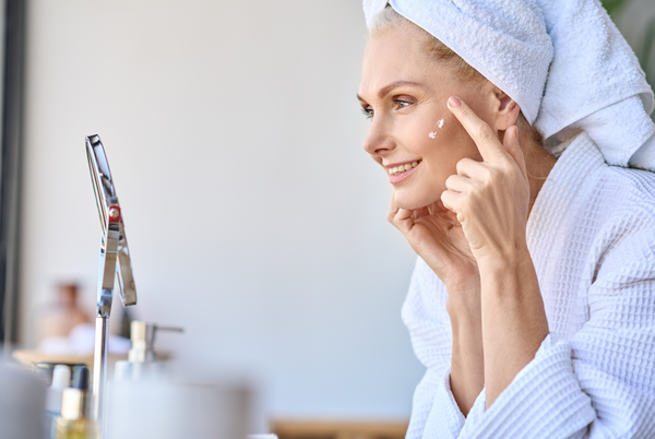 A woman aged 40 applying skincare cream 