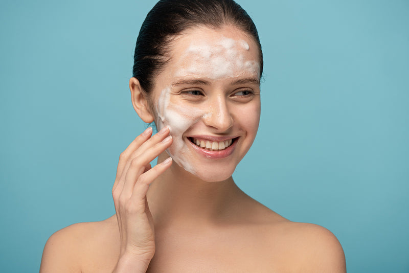 Woman applying skin cleanser