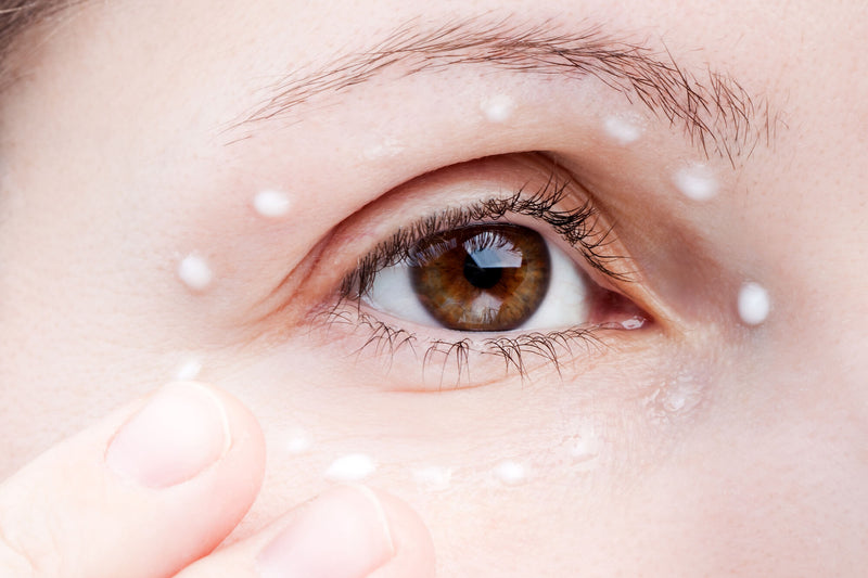 Woman applying eye skin care