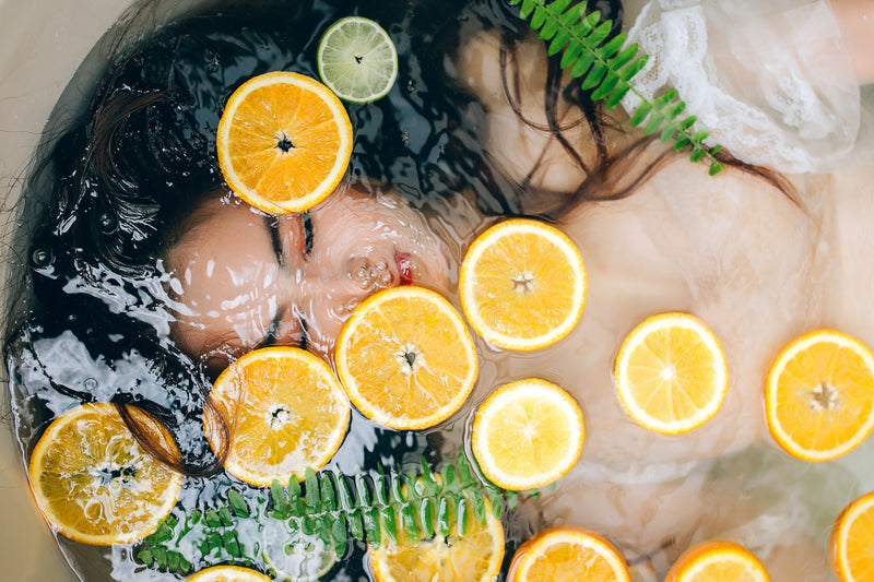 girl soaked in water full of oranges vitamin c