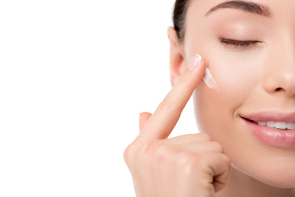woman applying moisturizing face cream