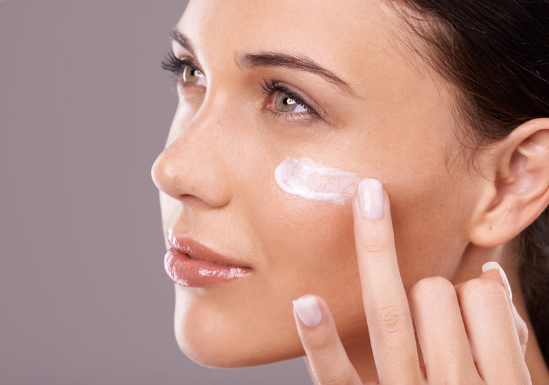 woman applying skincare product on her face